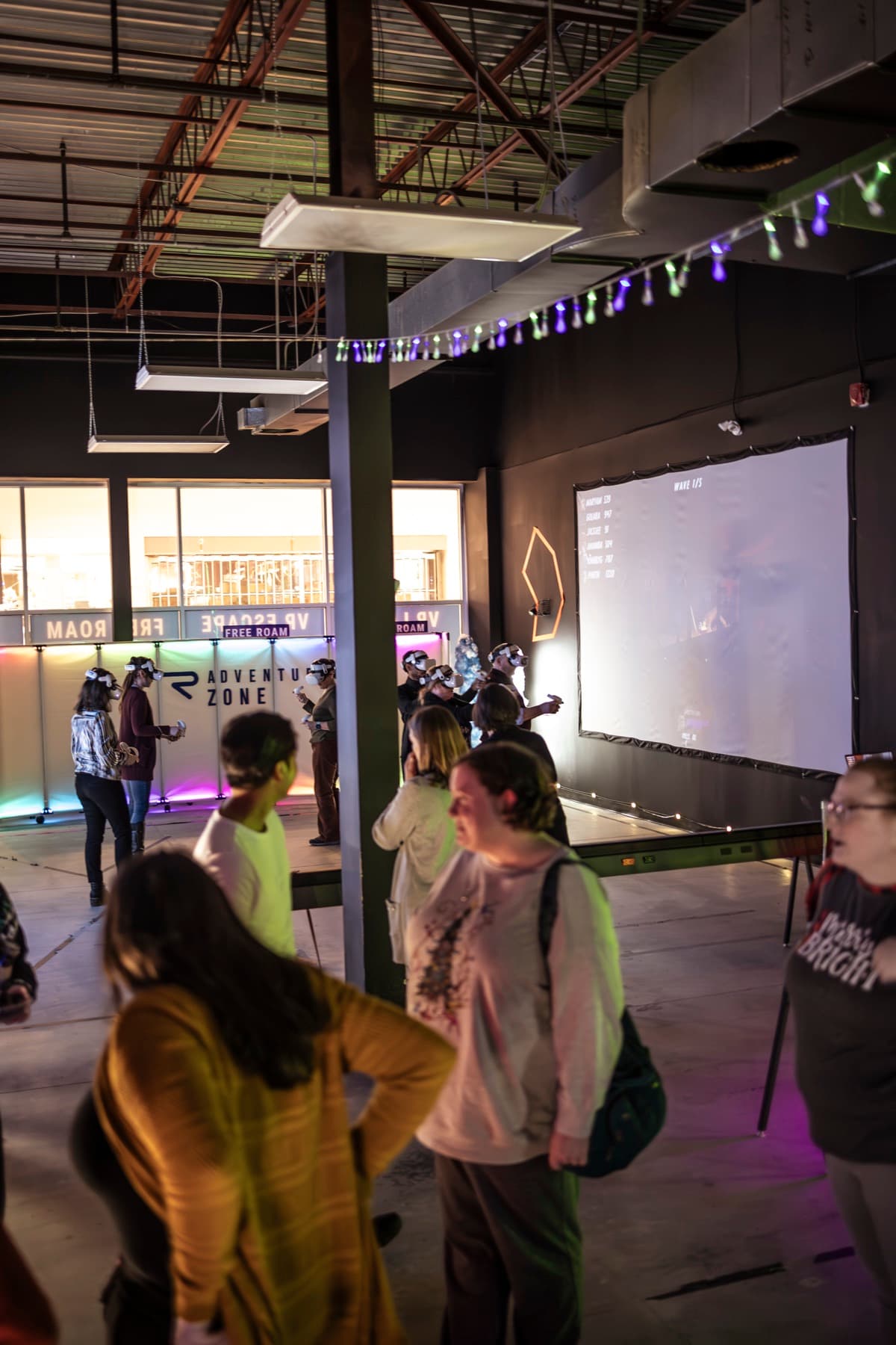 Coworkers watching and chatting while a group plays VR on stage